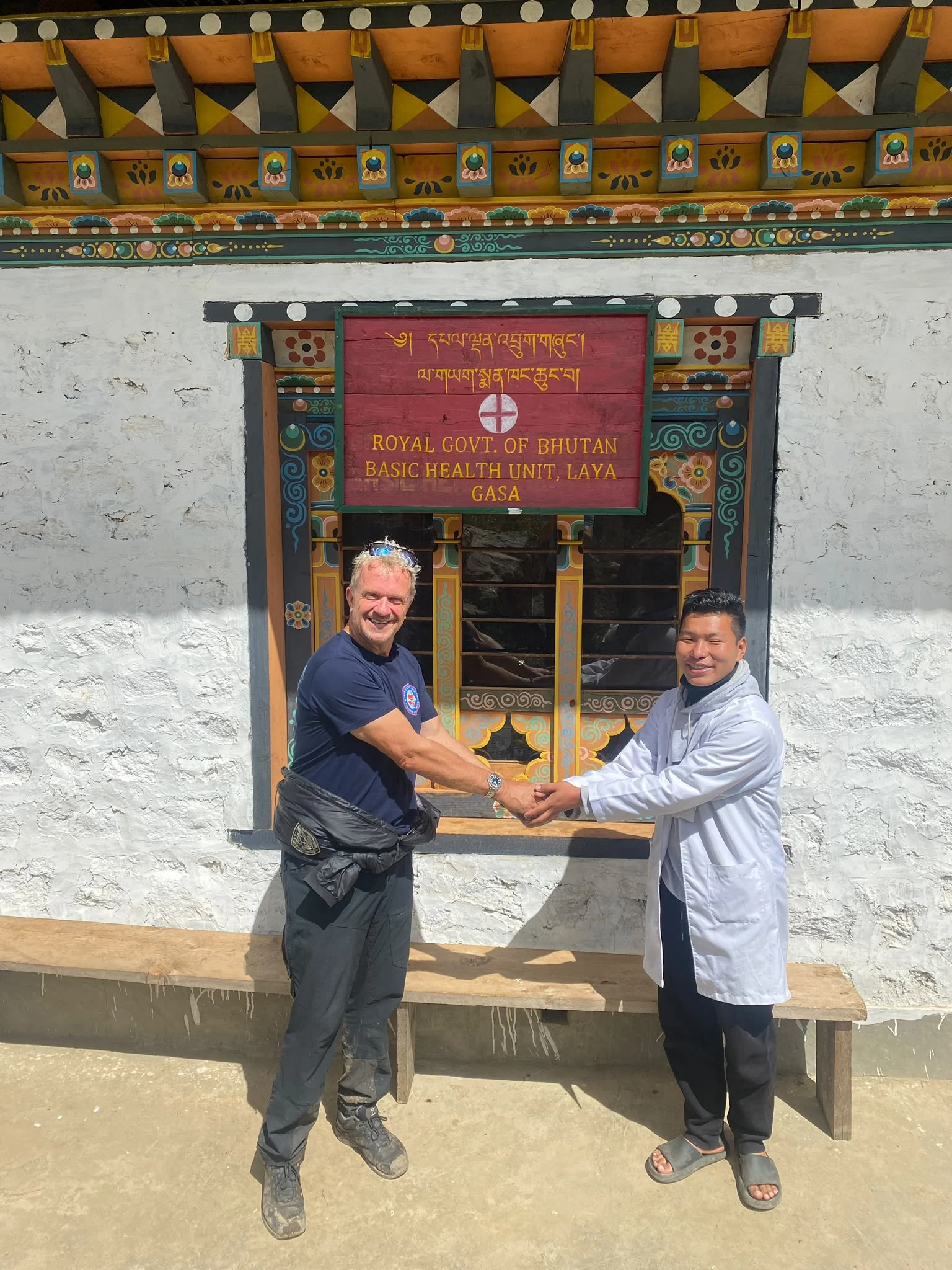 A Traverse representative and Bhutanese health worker meeting outside the Basic Health Unit in Laya