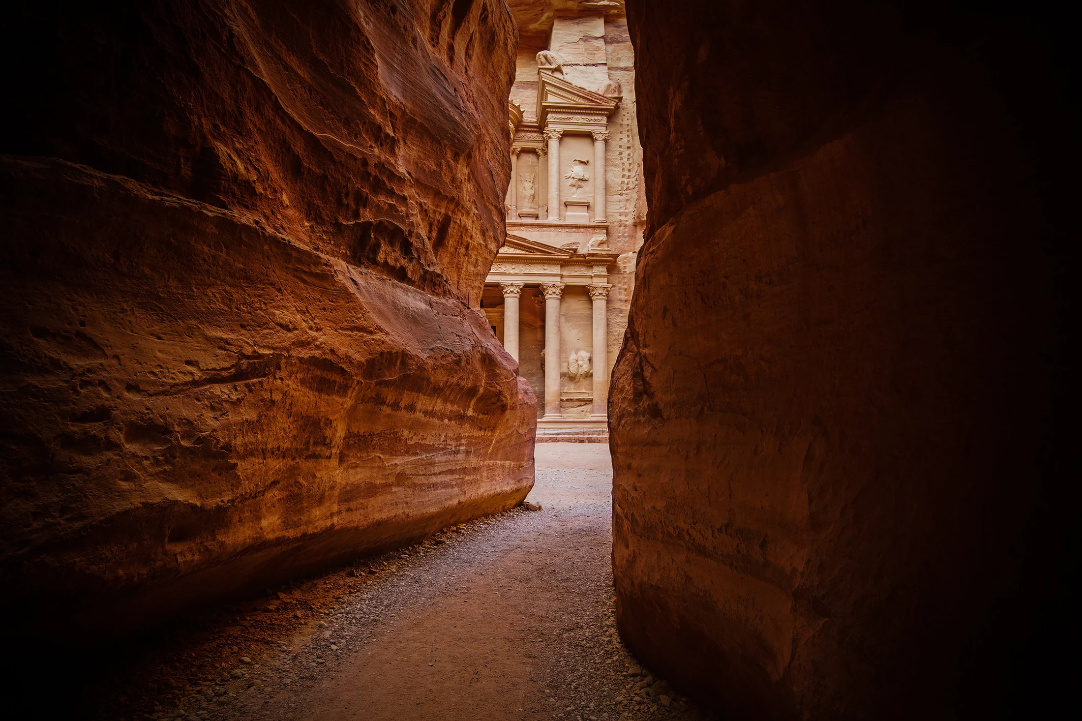 The Treasury at Petra seen through the narrow sandstone walls of the Siq